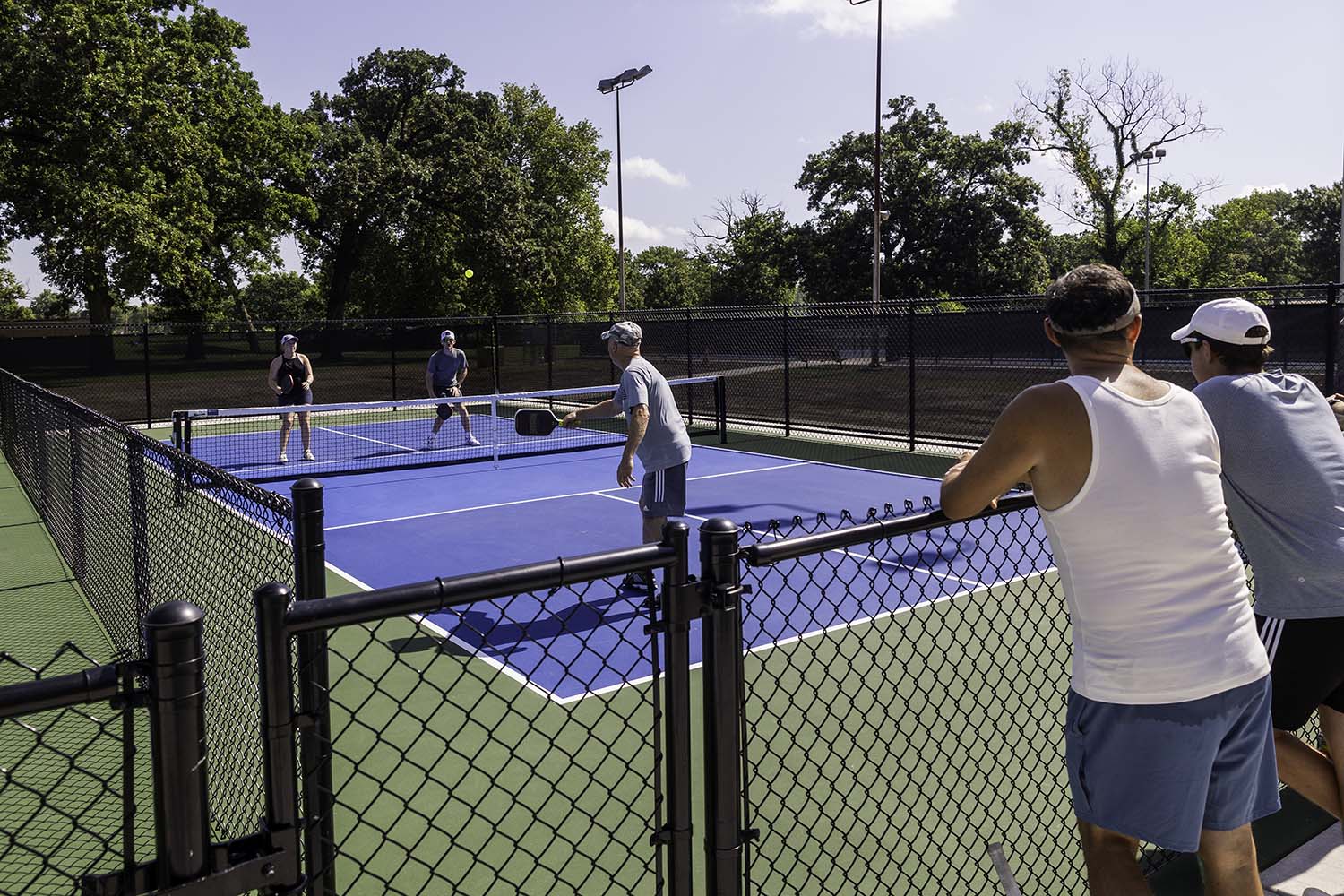 Adults playing pickleball at the Johnson Pickleball Court at Lincoln Park in Pittsburg, Kansas.